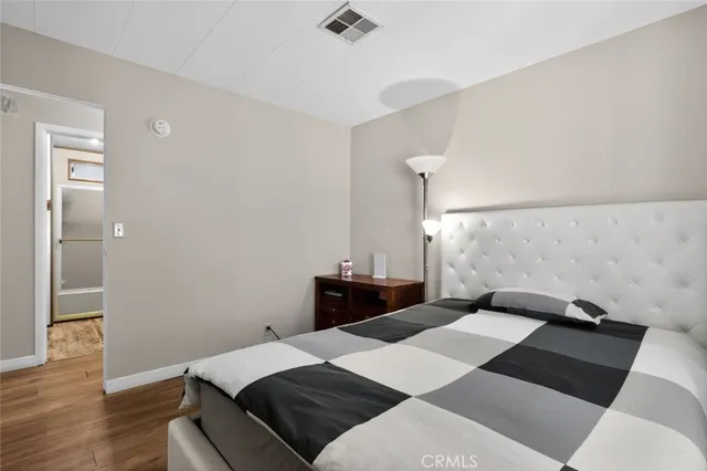 a bedroom with a bed and wooden floor