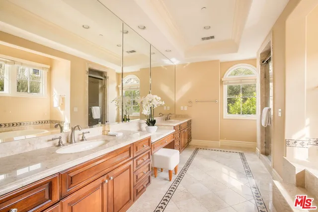 a spacious bathroom with a double vanity sink a mirror and a bathtub