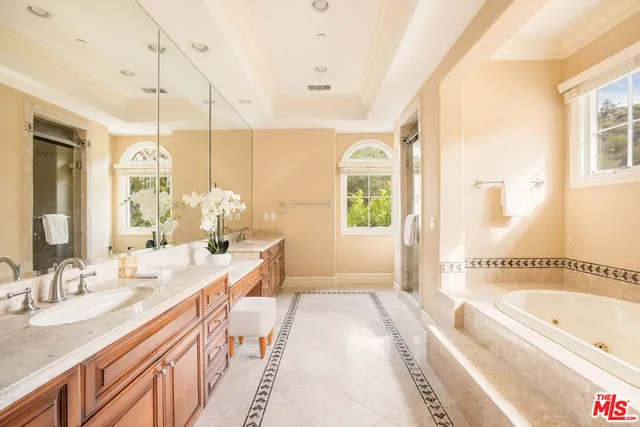 a spacious bathroom with a granite countertop tub sink and mirror
