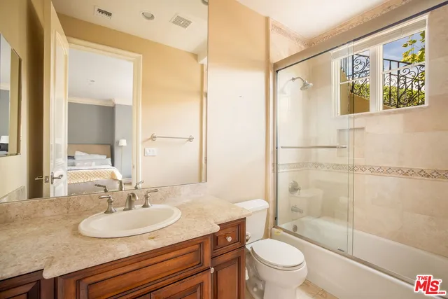 a bathroom with a granite countertop sink toilet and shower