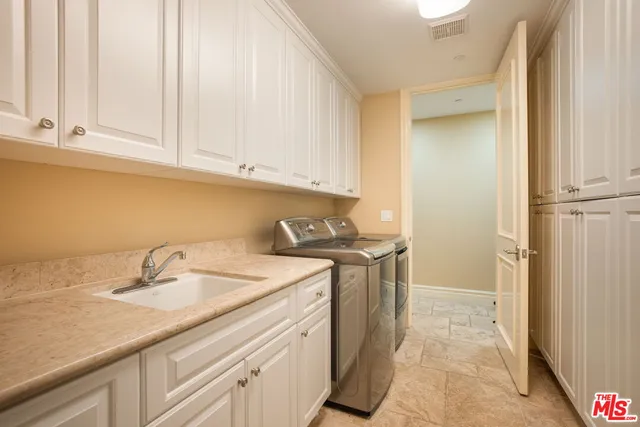 a utility room with sink dryer and washer