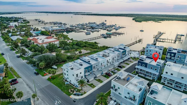 an aerial view of a city with lots of residential buildings ocean and mountain view in back