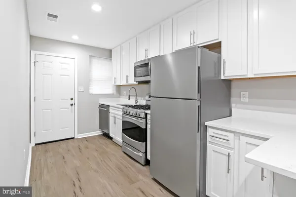 a kitchen with a refrigerator sink stove and cabinets