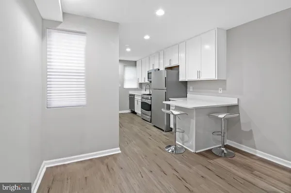 a kitchen with wooden floors and white appliances