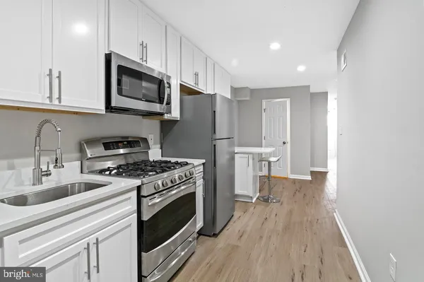 a kitchen with a stove a sink and a microwave
