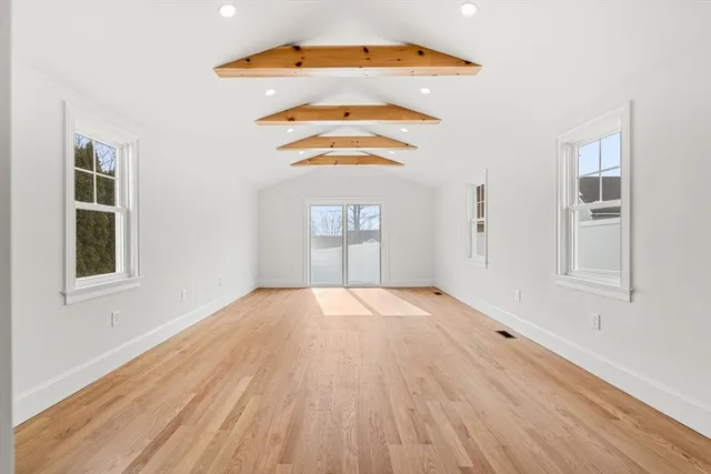 an empty room with windows and wooden floor
