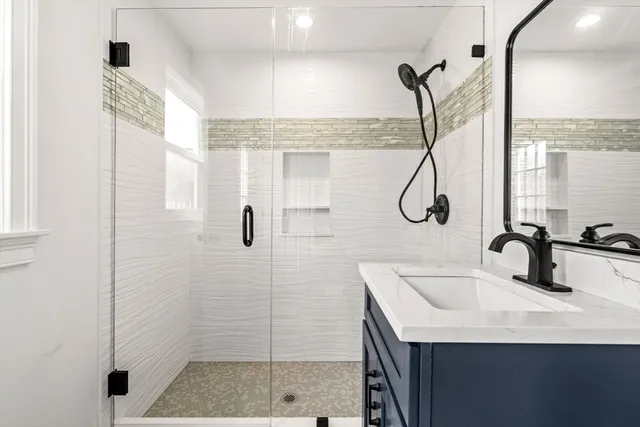a bathroom with a sink a mirror and shower