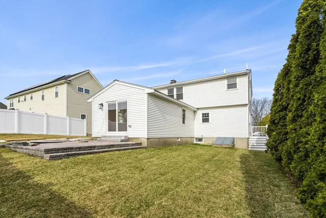 a big white house with a large trees with yard in front of it