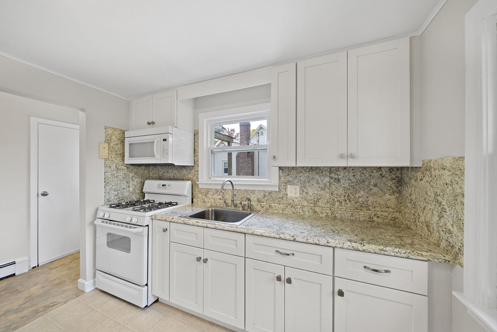 250-252 Mechanic Street Canton, MA 02021 - Photo 7 of 42 a kitchen with white cabinets and white appliances