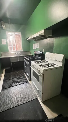 a kitchen with a stove and a wooden floor