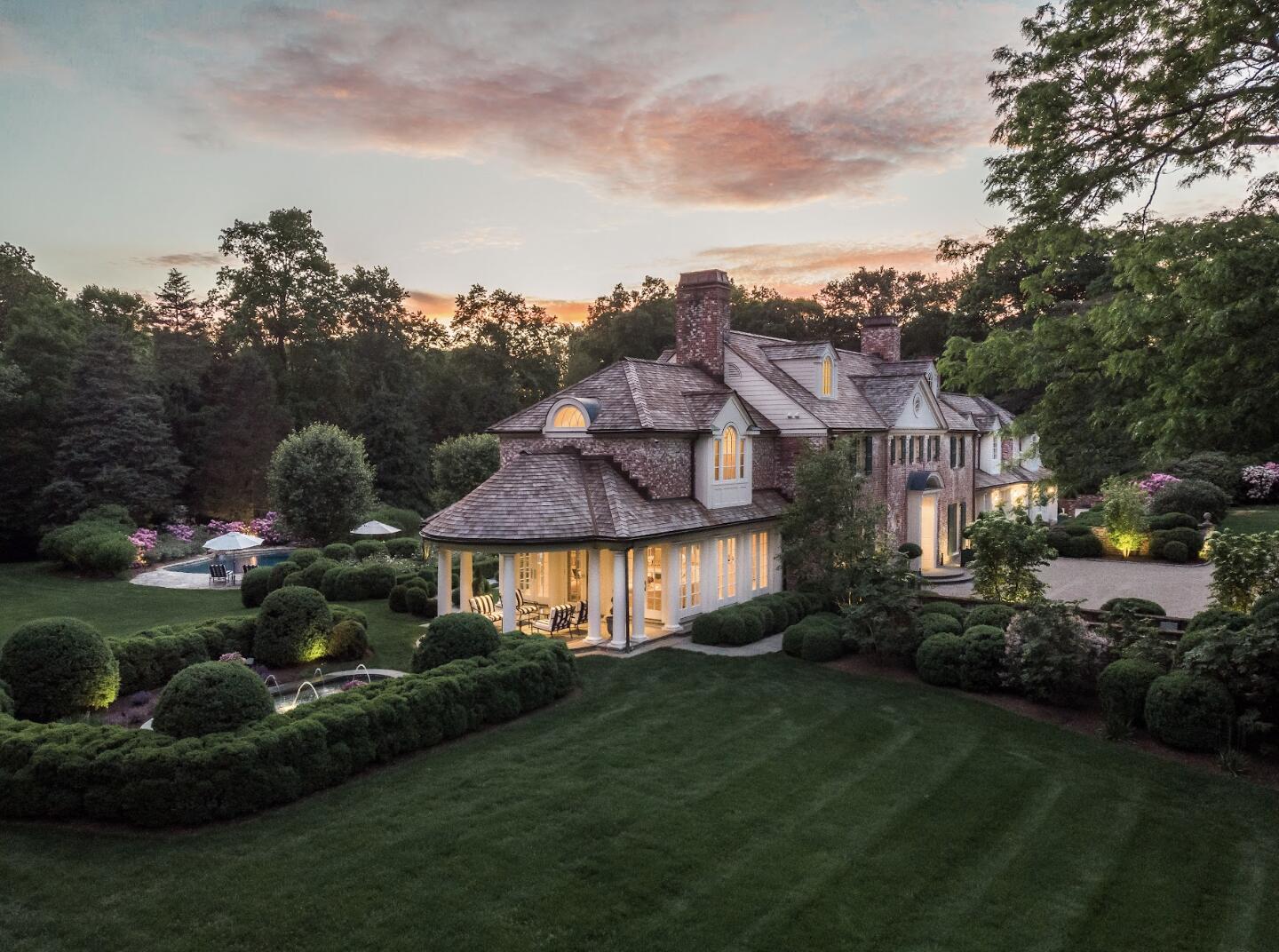 1024 Smith Ridge Road New Canaan, CT 06840 - Photo 2 of 40 a front view of a house with garden