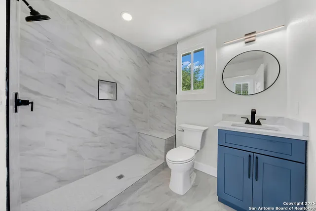 a bathroom with a sink a toilet and a mirror