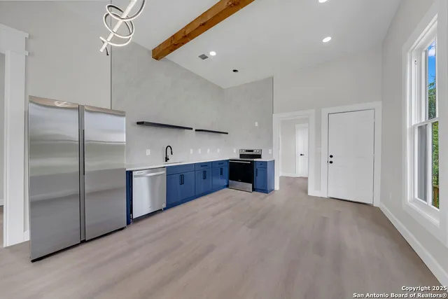a large kitchen with stainless steel appliances granite countertop a refrigerator and a sink