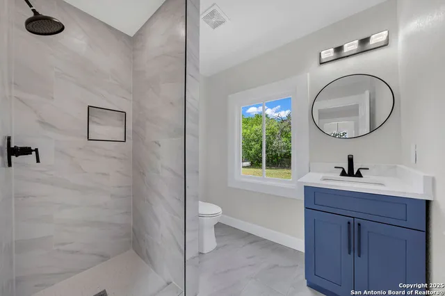 a bathroom with a sink a toilet and a window