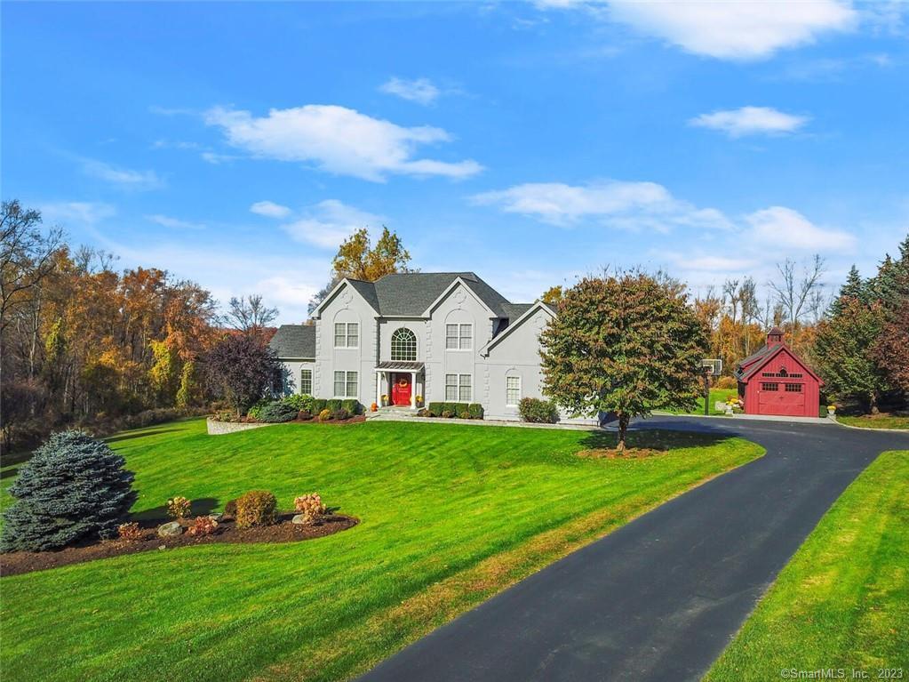a view of a white house with a big yard and potted plants
