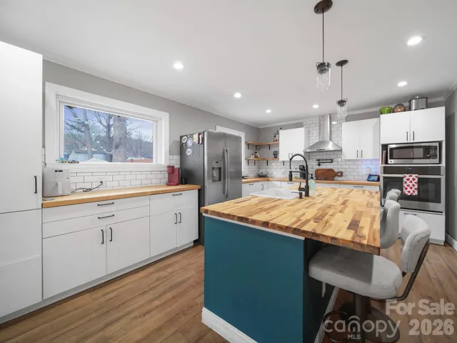 a kitchen with stainless steel appliances granite countertop sink stove refrigerator and cabinets