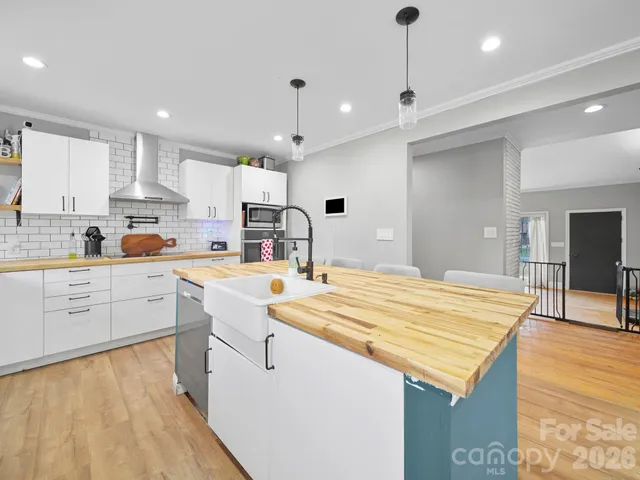 a kitchen with stainless steel appliances granite countertop a sink stove and white cabinets