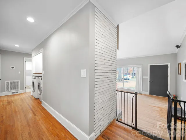 a view of a hallway with a dining room and wooden floor