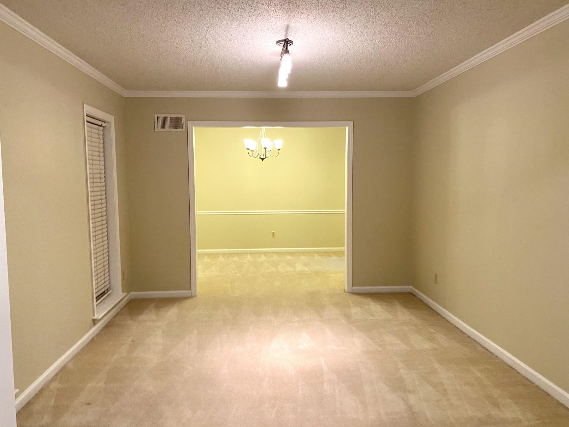 7918 Farmingdale Road Germantown, TN 38138 - Photo 8 of 12 Unfurnished room with ornamental molding, a chandelier, a textured ceiling, and carpet