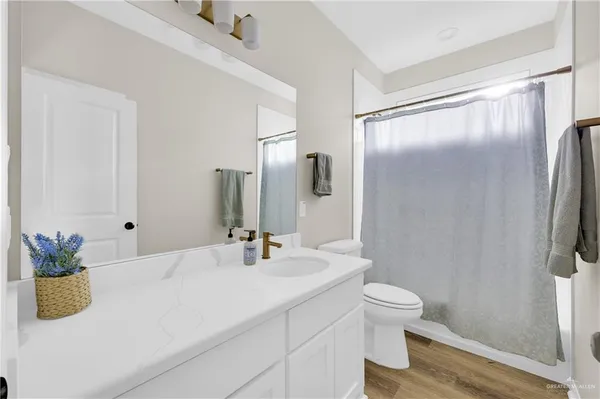a bathroom with a granite countertop sink a toilet and a large mirror