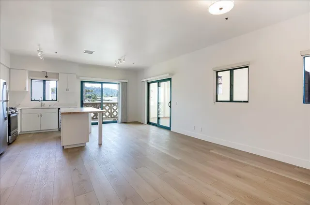a view of a kitchen with furniture and wooden floor
