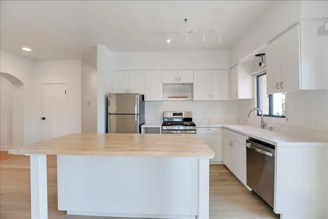 a kitchen with stainless steel appliances a sink stove and refrigerator
