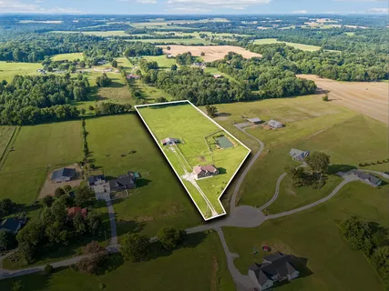 an aerial view of a residential houses with outdoor space and city view