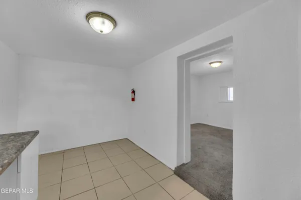 an empty room with white walls and tiles
