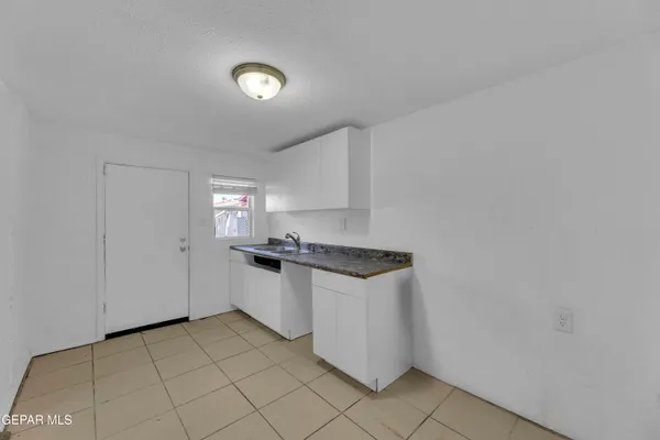 a kitchen with granite countertop a sink and a stove