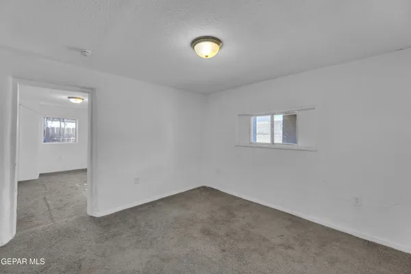 an empty room with window and mirror