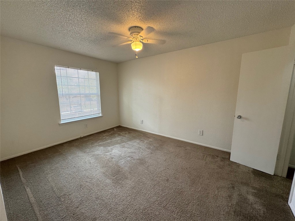 4810 West Wind Trail, Unit 103 Austin, TX 78745 - Photo 16 of 23 an empty room with windows and chandelier fan