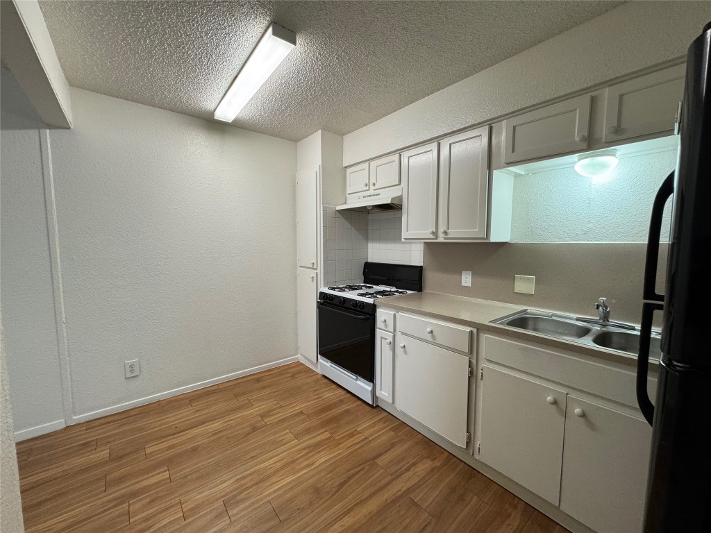 4810 West Wind Trail, Unit 103 Austin, TX 78745 - Photo 6 of 23 a kitchen with a sink stove and cabinets