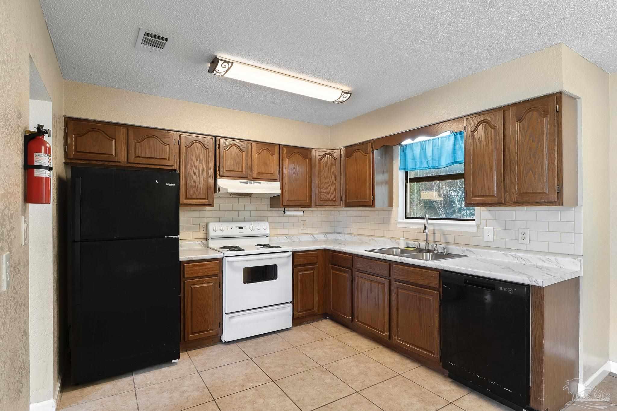 3135 Bent Oak Road Pensacola, FL 32526 - Photo 11 of 47 a kitchen with a sink stove and refrigerator