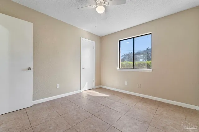 a view of an empty room with closet and a window