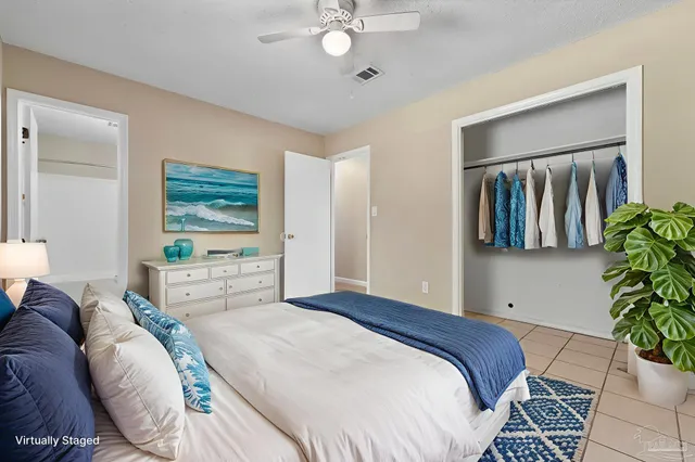 a bedroom with a large bed and a potted plant
