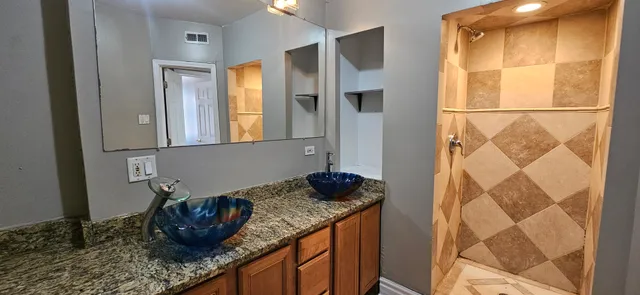 a bathroom with a granite countertop sink and a mirror
