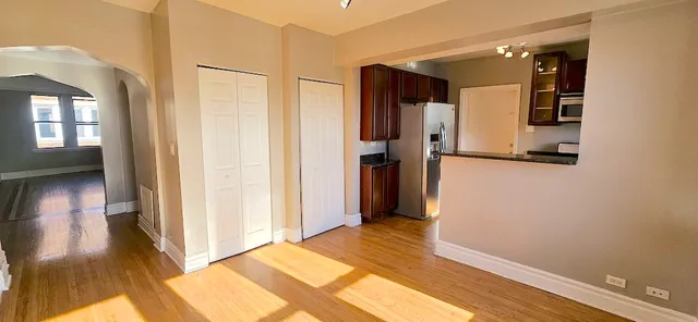 a view of a hallway with wooden floor and staircase