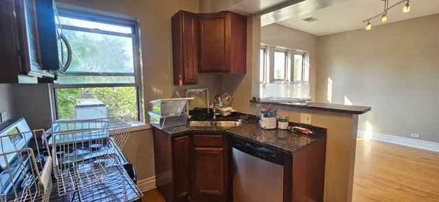 a kitchen with granite countertop a sink stove and cabinets