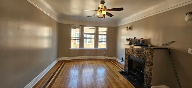 a view of hallway with a fireplace and wooden floor