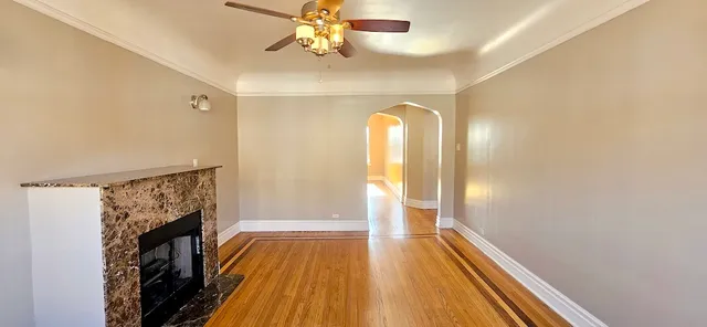 a view of a livingroom with wooden floor and a ceiling fan