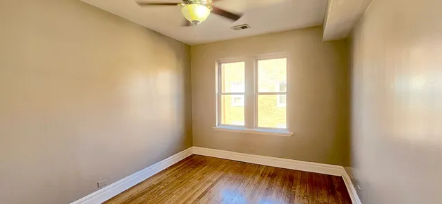 an empty room with a window and wooden floor