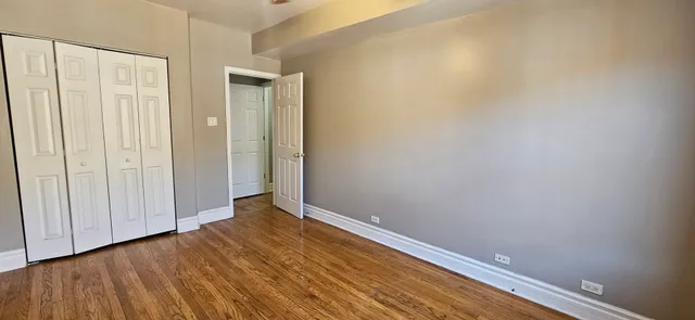 a view of an empty room with closet and a window