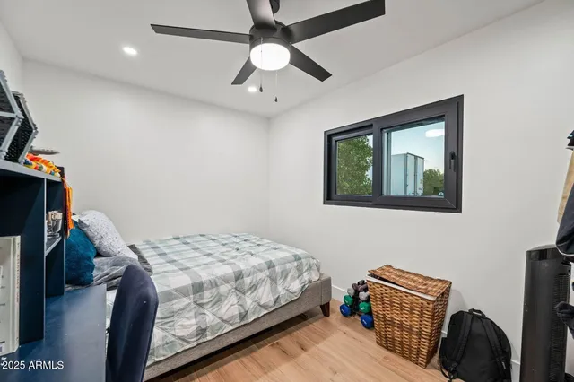 a bedroom with a bed and a ceiling fan