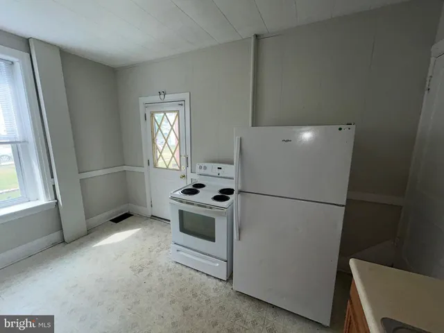 a white refrigerator freezer and a stove sitting inside of a kitchen