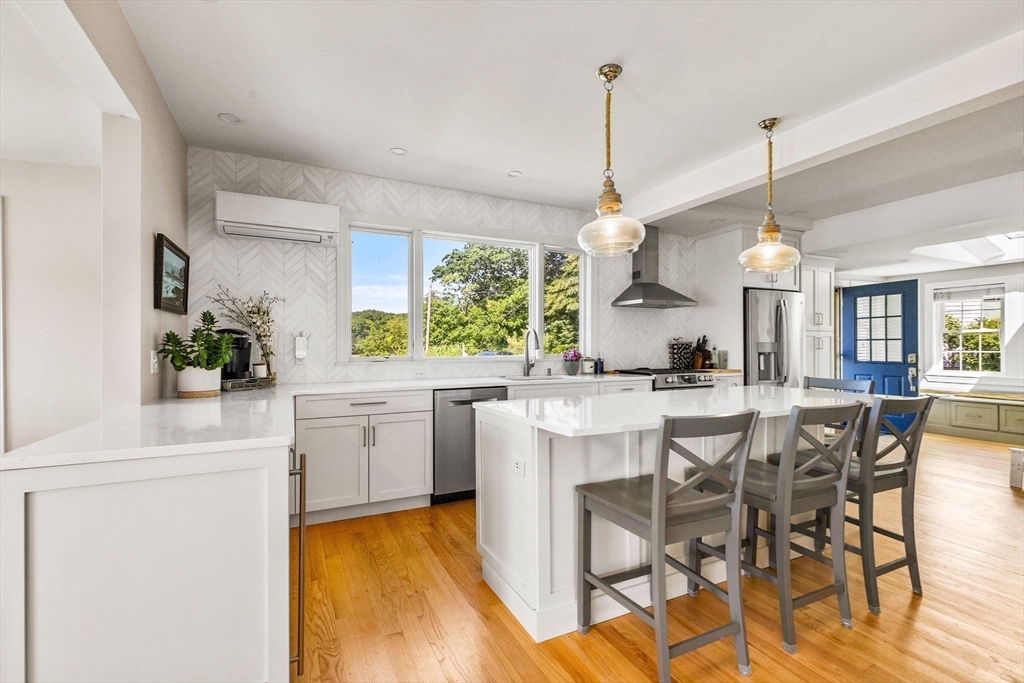 34 Cliff Road Hingham, MA 02043 - Photo 4 of 24 a kitchen with stainless steel appliances granite countertop a stove a sink dishwasher and a dining table with the kitchen view