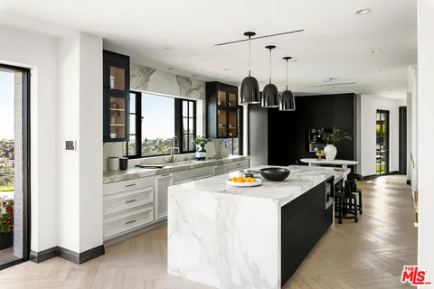 a kitchen with stainless steel appliances granite countertop a stove and a view of living room