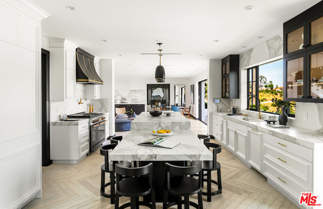 10932 Savona Road Los Angeles, CA 90077 - Photo 21 of 72 a kitchen with stainless steel appliances a dining table and chairs