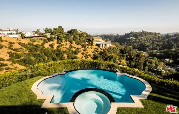 an aerial view of a house with a yard swimming pool and outdoor seating