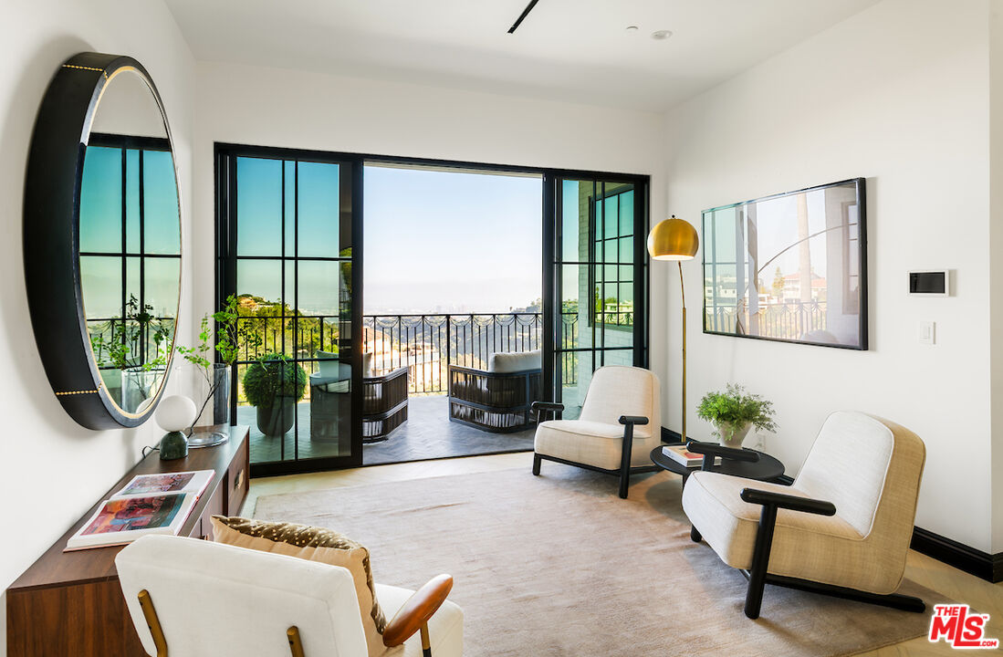 10932 Savona Road Los Angeles, CA 90077 - Photo 37 of 72 a living room with furniture a lamp a rug and a large window