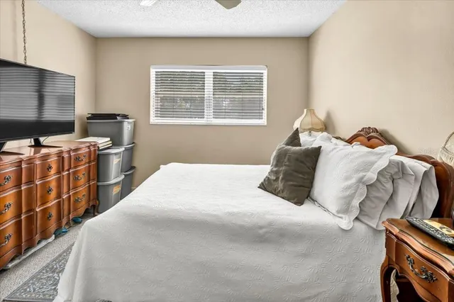 a bedroom with a bed next to a window with storage